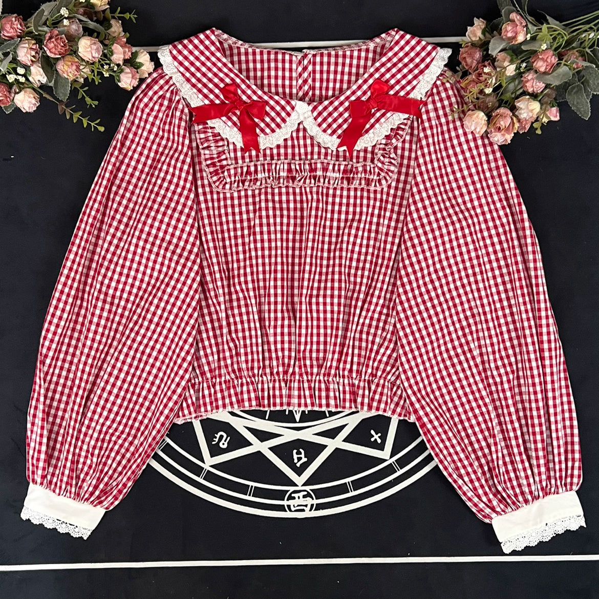 Crafted from breathable cotton, this charming short-sleeve blouse features a classic Peter Pan collar and delicate bow tie. The playful plaid pattern in multiple colors offers versatile styling for both Lolita and JK fashion. Its lightweight comfort and sweet design make it ideal for daily wear, effortlessly pairing with jumpers, skirts, or dresses for a fresh, youthful look.