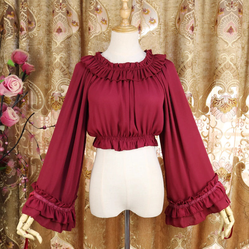 This flowing chiffon blouse combines delicate details with dramatic flared sleeves. Rendered in classic black, white, and bold red, its loose round neck design offers comfortable versatility for layering under JSKs or jumpers. The lightweight fabric and romantic silhouette create an elegant yet functional piece, perfect for adding dynamic movement and vintage charm to both sweet and Gothic Lolita coordinations.