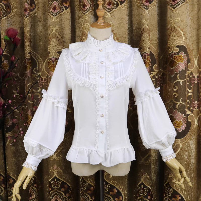 This vintage-inspired blouse features an elegant stand collar and voluminous lantern sleeves crafted from lightweight chiffon. The tailored silhouette offers a flattering fit, while delicate lace details add romantic refinement. Perfect for layering under dresses or jumpers, it blends retro sophistication with Lolita elegance, creating a timeless foundation for both classic and sweet coordinates.