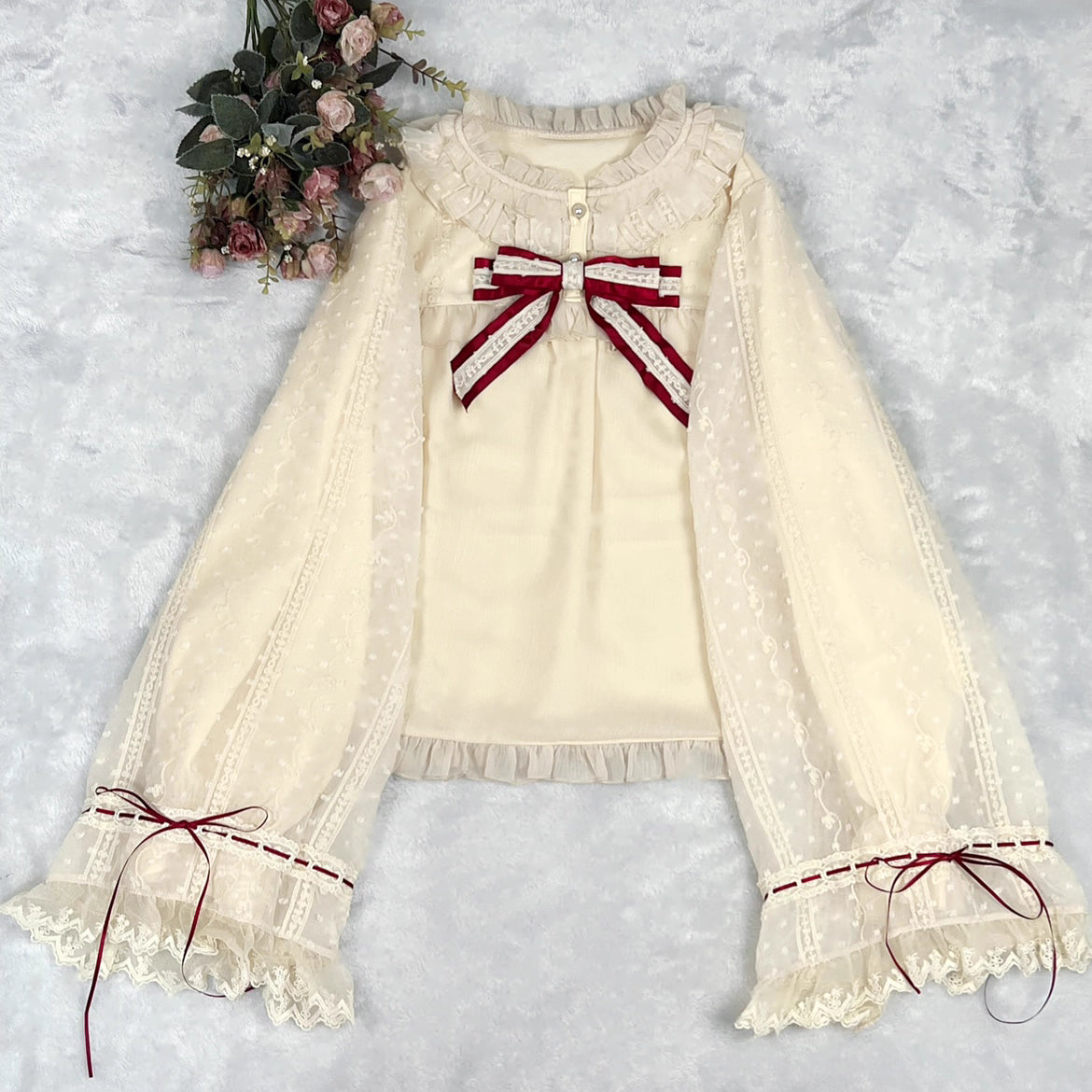 This elegant blouse masterfully blends Victorian romance with subtle Chinese-inspired aesthetics. The dramatic double-layer bishop sleeves and delicate drawstring details create a luxurious, poetic silhouette. Topped with a classic bow tie, it offers a timeless look. Designed for the modern Lolita enthusiast, this undershirt is crafted from premium materials for both comfort and sophistication, making it the perfect foundational piece for creating a statement layered outfit that is both graceful and uniquel