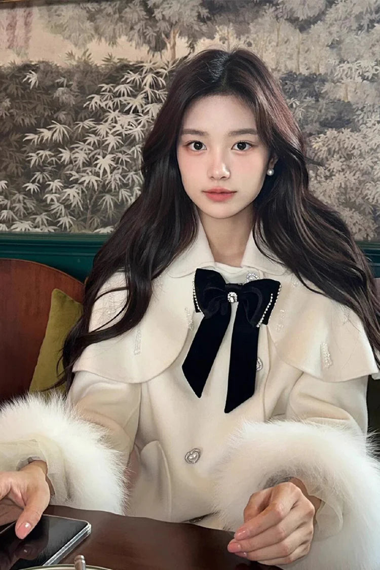 Blending whimsy with elegance, this cape coat transforms classic Lolita charm into a versatile outerwear piece. The playful rabbit ears and delicate bow contrast the monochrome palette, creating a striking balance between sweetness and sophistication. Designed with a flowing silhouette and single-row button closure, it offers effortless layering for cool days—perfect for adding a touch of fantasy to both casual and formal Lolita coordinates.