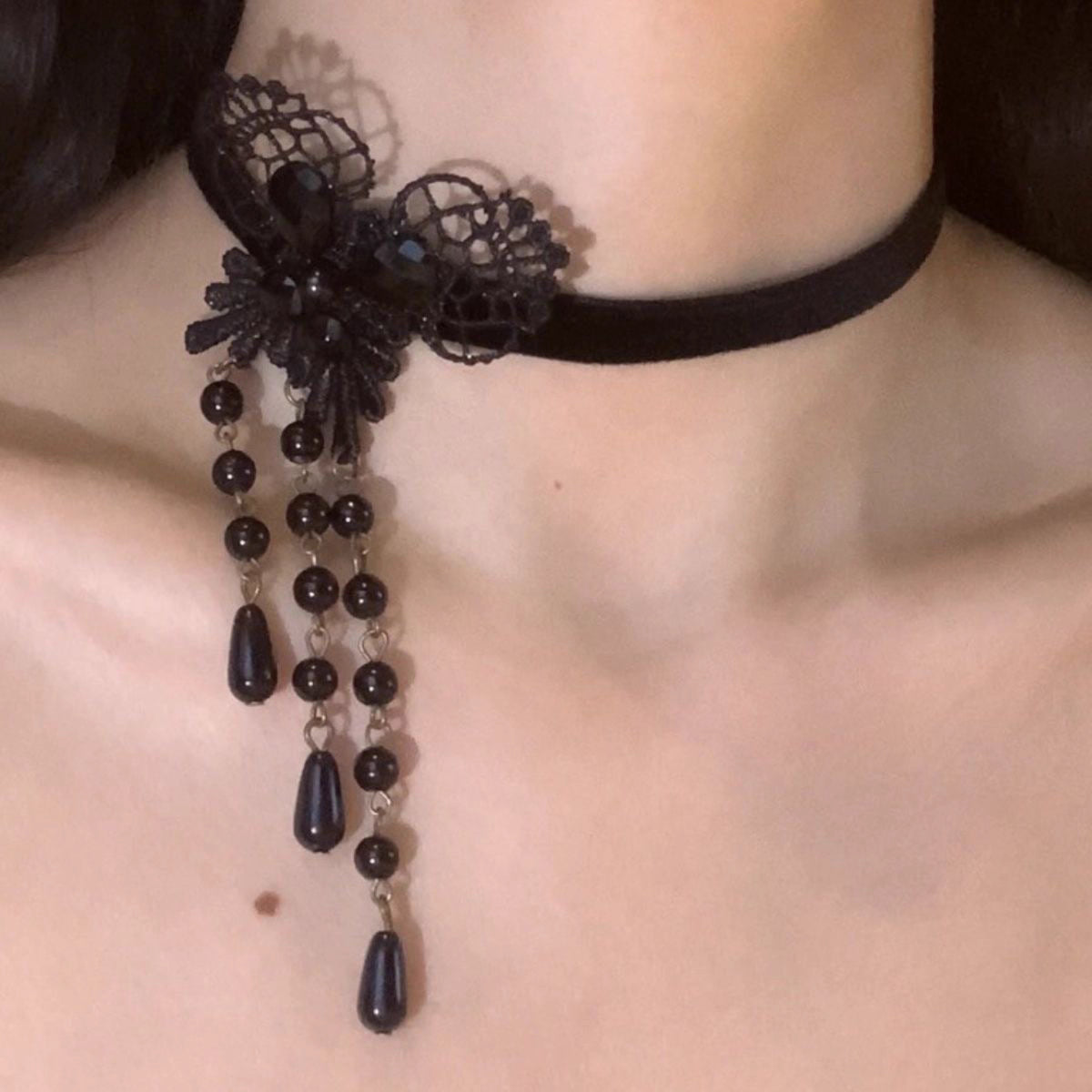 This Lolita Gothic Choker Necklace blends elegance with a dark romantic charm. Crafted from delicate black lace, it features a butterfly centerpiece adorned with pearls and flowing tassels, creating a graceful layered look. Designed to highlight the collarbone, it adds both mystery and sophistication to any outfit. Perfect for gothic Lolita ensembles, parties, or special occasions, this accessory is a refined statement piece that enhances the allure of classic dark Lolita style.