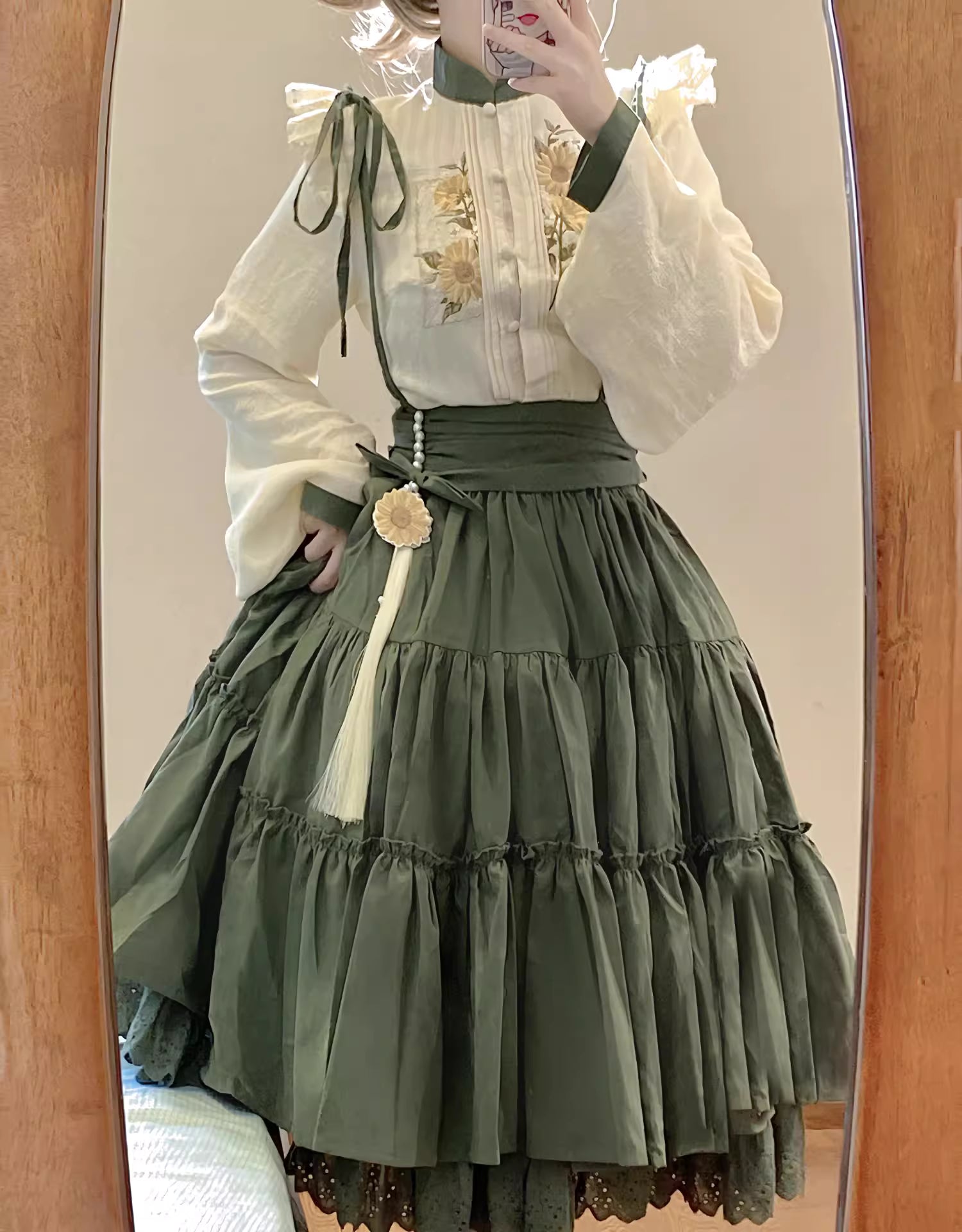 This Green Sunflower Embroidery Lolita Set blends the elegance of Hanfu-inspired details with the sweetness of classic Lolita fashion. The delicate sunflower embroidery brings a fresh pastoral charm, while the layered JSK and long-sleeve blouse create a refined silhouette. Designed for comfort and beauty, it is perfect for spring and autumn wear. Whether for tea parties, garden walks, or seasonal gatherings, this set captures a graceful harmony of tradition and modern Lolita style.