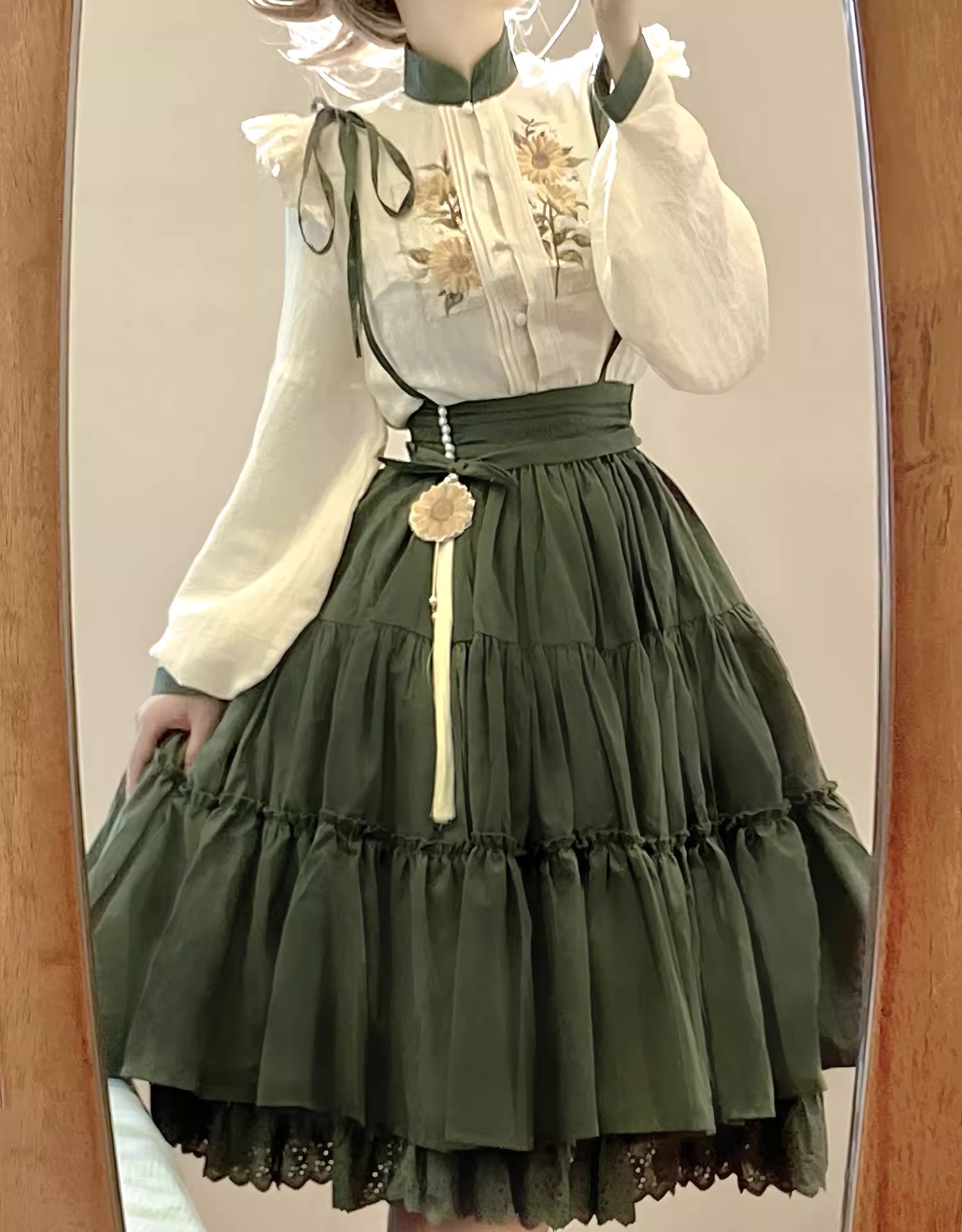 This Green Sunflower Embroidery Lolita Set blends the elegance of Hanfu-inspired details with the sweetness of classic Lolita fashion. The delicate sunflower embroidery brings a fresh pastoral charm, while the layered JSK and long-sleeve blouse create a refined silhouette. Designed for comfort and beauty, it is perfect for spring and autumn wear. Whether for tea parties, garden walks, or seasonal gatherings, this set captures a graceful harmony of tradition and modern Lolita style.
