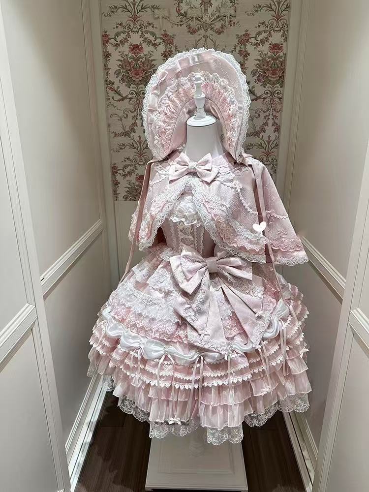 Design Concept:
This Sweet Lolita pink lace trimmed strappy JSK princess dress set embodies a delicate and charming style, combining soft pink tones with elegant lace details for a dreamy Lolita look. Product Details: The set includes a pink dress, a pin-on bow, an official matching inner petticoat, and a coordinating cape, creating a complete and enchanting outfit perfect for special occasions or Lolita fashion events.