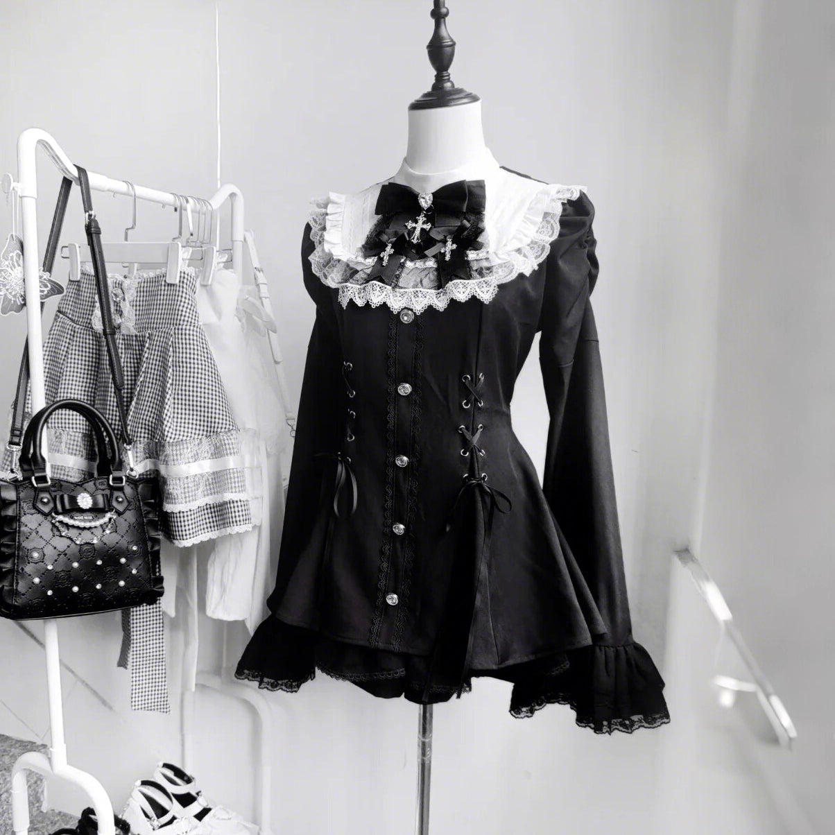This bell-sleeve Gothic Lolita dress combines dark elegance with petite-friendly proportions. Rendered in stark black and white, its A-line silhouette and delicate lace details create a whimsical yet edgy aesthetic. The dramatic sleeves and tailored waist flatter smaller frames, making it ideal for coordinations blending Japanese-inspired sweetness with timeless Gothic romance.