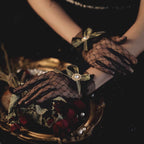 These gothic Lolita lace gloves are crafted with delicate sheer mesh and floral lace trim, blending elegance with sensual charm. The black design adds a mysterious gothic touch, while the thin fabric creates a graceful silhouette. Perfect for weddings, qipao styling, Halloween cosplay, or themed photo shoots, these gloves complete any Lolita or bridal-inspired outfit with timeless allure.
