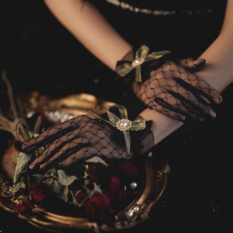 These gothic Lolita lace gloves are crafted with delicate sheer mesh and floral lace trim, blending elegance with sensual charm. The black design adds a mysterious gothic touch, while the thin fabric creates a graceful silhouette. Perfect for weddings, qipao styling, Halloween cosplay, or themed photo shoots, these gloves complete any Lolita or bridal-inspired outfit with timeless allure.