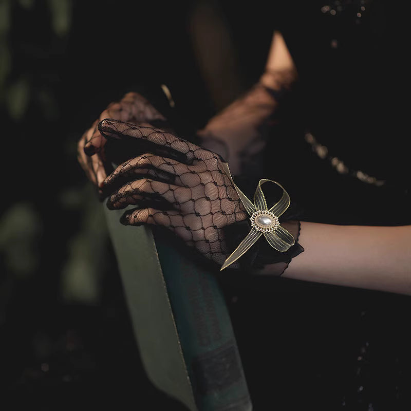 These gothic Lolita lace gloves are crafted with delicate sheer mesh and floral lace trim, blending elegance with sensual charm. The black design adds a mysterious gothic touch, while the thin fabric creates a graceful silhouette. Perfect for weddings, qipao styling, Halloween cosplay, or themed photo shoots, these gloves complete any Lolita or bridal-inspired outfit with timeless allure.