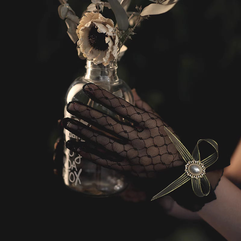 These gothic Lolita lace gloves are crafted with delicate sheer mesh and floral lace trim, blending elegance with sensual charm. The black design adds a mysterious gothic touch, while the thin fabric creates a graceful silhouette. Perfect for weddings, qipao styling, Halloween cosplay, or themed photo shoots, these gloves complete any Lolita or bridal-inspired outfit with timeless allure.
