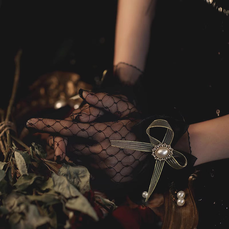 These gothic Lolita lace gloves are crafted with delicate sheer mesh and floral lace trim, blending elegance with sensual charm. The black design adds a mysterious gothic touch, while the thin fabric creates a graceful silhouette. Perfect for weddings, qipao styling, Halloween cosplay, or themed photo shoots, these gloves complete any Lolita or bridal-inspired outfit with timeless allure.