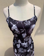 Embrace dark romance in this striking Gothic mini dress, where underground subculture meets high fashion. The bold skeleton and rose hand-print design creates a haunting visual narrative against the fitted silhouette. Designed with a built-in corset bustier for waist-cinching definition, this dress accentuates your curves while making a powerful street-style statement. Lightweight yet dramatic, it transitions seamlessly from concert venues to night markets. The adjustable straps and breathable fabric ensure