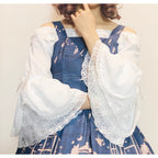 This elegant chiffon blouse features dramatic ruffled sleeves and a delicate bow accent, creating a romantic silhouette. The lightweight fabric drapes softly for effortless layering under jumpers or dresses. With its refined details and flowing texture, it blends vintage-inspired grace with modern Lolita charm, perfect for adding sophistication to any coordinate.