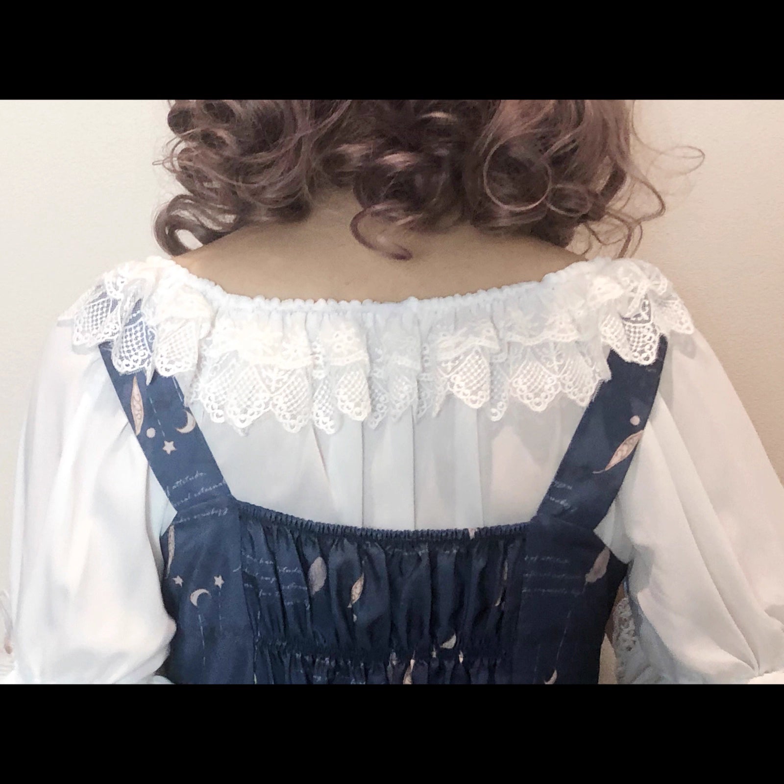 This elegant chiffon blouse features dramatic ruffled sleeves and a delicate bow accent, creating a romantic silhouette. The lightweight fabric drapes softly for effortless layering under jumpers or dresses. With its refined details and flowing texture, it blends vintage-inspired grace with modern Lolita charm, perfect for adding sophistication to any coordinate.
