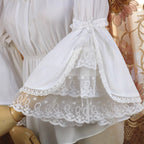 This elegant chiffon blouse features dramatic ruffled sleeves and a delicate bow accent, creating a romantic silhouette. The lightweight fabric drapes softly for effortless layering under jumpers or dresses. With its refined details and flowing texture, it blends vintage-inspired grace with modern Lolita charm, perfect for adding sophistication to any coordinate.
