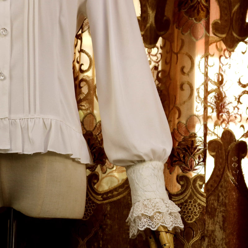 This vintage-inspired blouse features an elegant stand collar and delicate ruffled sleeves crafted from lightweight chiffon. The tailored fit and button-front design create a flattering silhouette, perfect for layering under jumpers or dresses. Its timeless elegance blends retro charm with Lolita sophistication, making it ideal for both classic and sweet coordinates.