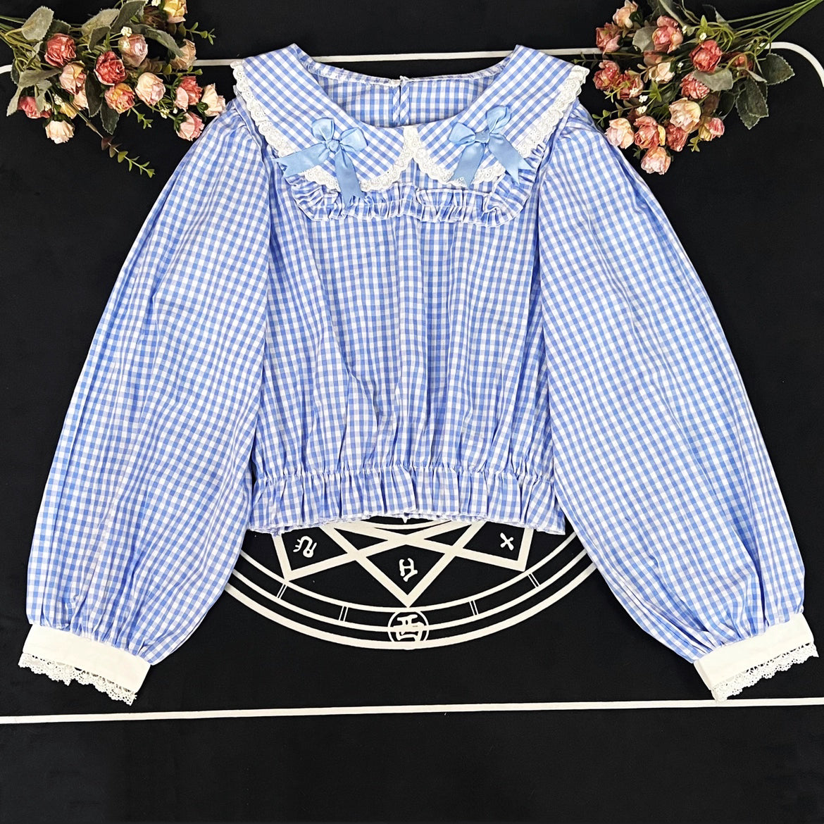 Crafted from breathable cotton, this charming short-sleeve blouse features a classic Peter Pan collar and delicate bow tie. The playful plaid pattern in multiple colors offers versatile styling for both Lolita and JK fashion. Its lightweight comfort and sweet design make it ideal for daily wear, effortlessly pairing with jumpers, skirts, or dresses for a fresh, youthful look.