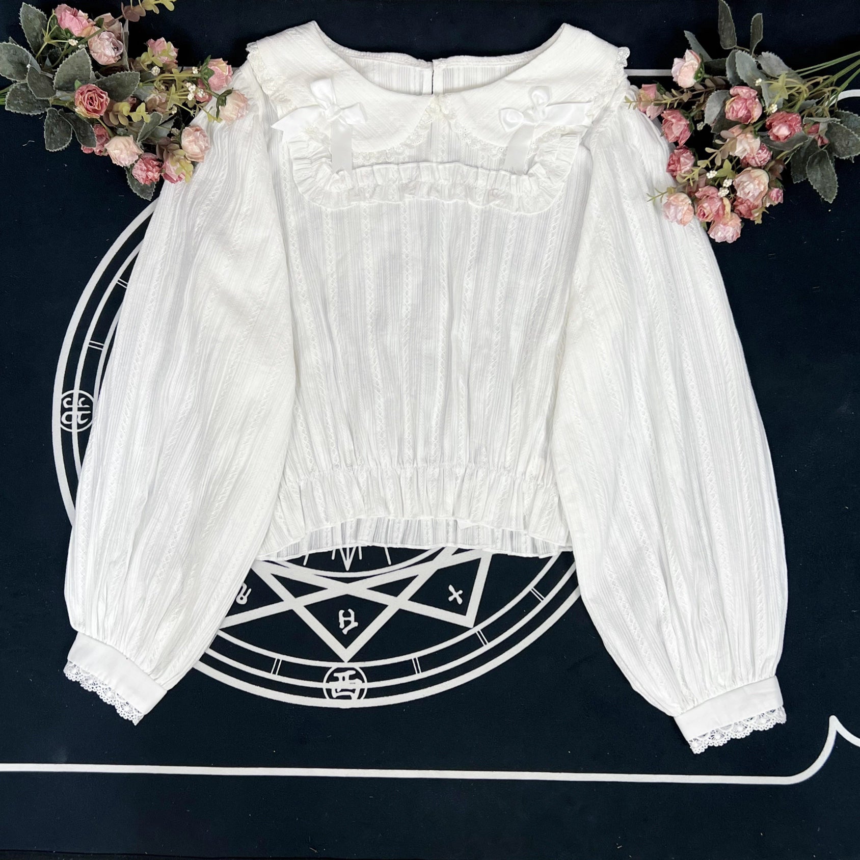 Crafted from breathable cotton, this charming short-sleeve blouse features a classic Peter Pan collar and delicate bow tie. The playful plaid pattern in multiple colors offers versatile styling for both Lolita and JK fashion. Its lightweight comfort and sweet design make it ideal for daily wear, effortlessly pairing with jumpers, skirts, or dresses for a fresh, youthful look.