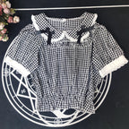 Crafted from breathable cotton, this charming short-sleeve blouse features a classic Peter Pan collar and delicate bow tie. The playful plaid pattern in multiple colors offers versatile styling for both Lolita and JK fashion. Its lightweight comfort and sweet design make it ideal for daily wear, effortlessly pairing with jumpers, skirts, or dresses for a fresh, youthful look.