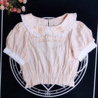 Crafted from breathable cotton, this charming short-sleeve blouse features a classic Peter Pan collar and delicate bow tie. The playful plaid pattern in multiple colors offers versatile styling for both Lolita and JK fashion. Its lightweight comfort and sweet design make it ideal for daily wear, effortlessly pairing with jumpers, skirts, or dresses for a fresh, youthful look.
