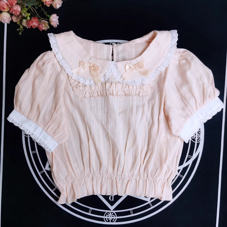 Crafted from breathable cotton, this charming short-sleeve blouse features a classic Peter Pan collar and delicate bow tie. The playful plaid pattern in multiple colors offers versatile styling for both Lolita and JK fashion. Its lightweight comfort and sweet design make it ideal for daily wear, effortlessly pairing with jumpers, skirts, or dresses for a fresh, youthful look.