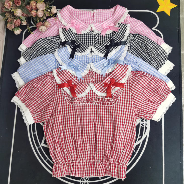 Crafted from breathable cotton, this charming short-sleeve blouse features a classic Peter Pan collar and delicate bow tie. The playful plaid pattern in multiple colors offers versatile styling for both Lolita and JK fashion. Its lightweight comfort and sweet design make it ideal for daily wear, effortlessly pairing with jumpers, skirts, or dresses for a fresh, youthful look.