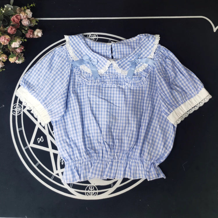 Crafted from breathable cotton, this charming short-sleeve blouse features a classic Peter Pan collar and delicate bow tie. The playful plaid pattern in multiple colors offers versatile styling for both Lolita and JK fashion. Its lightweight comfort and sweet design make it ideal for daily wear, effortlessly pairing with jumpers, skirts, or dresses for a fresh, youthful look.