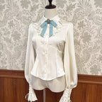 Inspired by the delicate charm of a dollhouse aesthetic, this long-sleeve Lolita blouse combines minimalist elegance with functional design. Crafted in pure white and classic black with a graceful drape, it features adjustable tie details for customizable silhouettes. The versatile piece offers a comfortable fit for daily wear, effortlessly layering under jumpers or pairing with high-waisted skirts. Its subtle sophistication makes it ideal for both sweet and Gothic Lolita coordinations, blending timeless pu