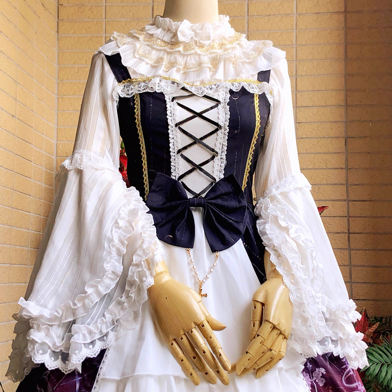 This elegant blouse combines luxurious gold-trimmed stripes with flowing chiffon fabric and dramatic sleeves. The metallic accents catch the light beautifully, adding opulence to the delicate striped pattern. Perfect for layering, it creates a sophisticated foundation for both classic and aristocratic Lolita styles, blending regal charm with timeless elegance.