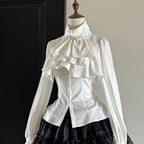 Step into Victorian elegance with this Gothic Lolita blouse. Delicate ruffles frame the Peter Pan collar and cascade down the front, while billowy bishop sleeves add dramatic flair. Crafted from premium opaque fabric, this retro-inspired top features intricate lace detailing and a tailored fit. Available in classic black, vampy red, and pristine white, it serves as the perfect layering piece for JSKs or a statement standalone top. Embrace dark romance with this timeless essential.