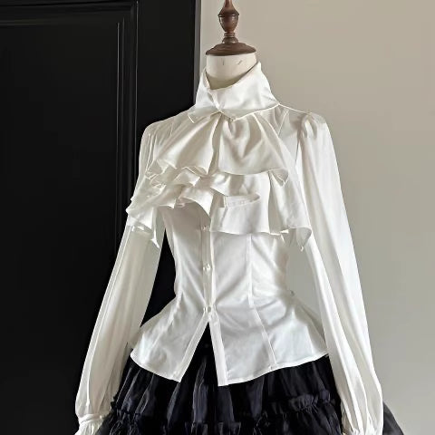 Step into Victorian elegance with this Gothic Lolita blouse. Delicate ruffles frame the Peter Pan collar and cascade down the front, while billowy bishop sleeves add dramatic flair. Crafted from premium opaque fabric, this retro-inspired top features intricate lace detailing and a tailored fit. Available in classic black, vampy red, and pristine white, it serves as the perfect layering piece for JSKs or a statement standalone top. Embrace dark romance with this timeless essential.