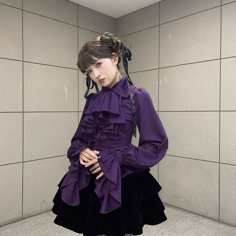 Step into Victorian elegance with this Gothic Lolita blouse. Delicate ruffles frame the Peter Pan collar and cascade down the front, while billowy bishop sleeves add dramatic flair. Crafted from premium opaque fabric, this retro-inspired top features intricate lace detailing and a tailored fit. Available in classic black, vampy red, and pristine white, it serves as the perfect layering piece for JSKs or a statement standalone top. Embrace dark romance with this timeless essential.
