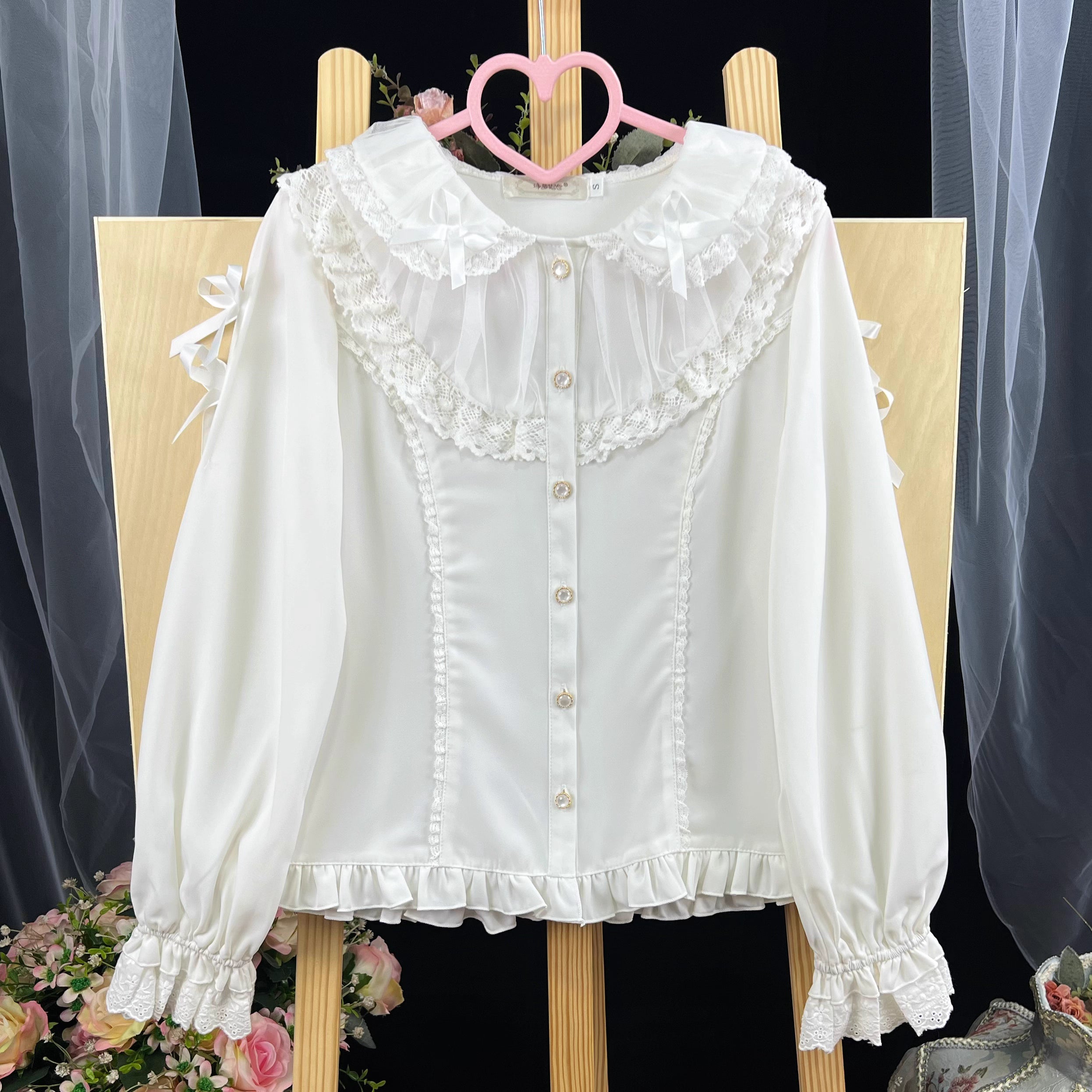 This exquisite Lolita blouse showcases a heavily detailed Peter Pan collar with intricate lace and embroidery. Rendered in vibrant red, pure white, and classic black, its long sleeves and tailored fit offer a perfect balance of sweetness and sophistication. The luxurious craftsmanship makes it ideal for creating striking coordinations, blending doll-like charm with elegant versatility for both daily wear and special occasions.