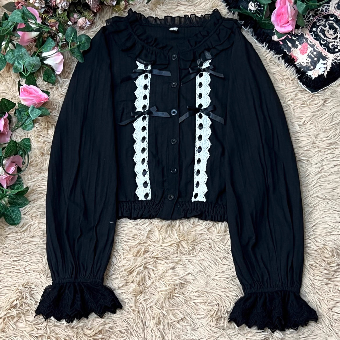 This short-cut cotton blouse features a flattering high-waist design and an elastic hem adorned with delicate ruffles. Crafted in versatile black and sweet pink, its breathable fabric and tailored fit offer comfort for daily wear. The cropped length perfectly pairs with high-waisted skirts or jumpers, blending playful charm with practical elegance for cute Lolita coordinates.