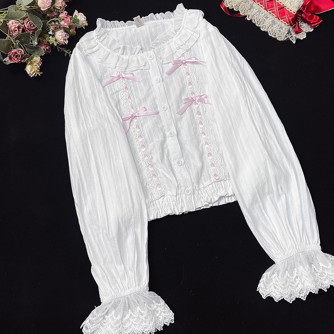 This short-cut cotton blouse features a flattering high-waist design and an elastic hem adorned with delicate ruffles. Crafted in versatile black and sweet pink, its breathable fabric and tailored fit offer comfort for daily wear. The cropped length perfectly pairs with high-waisted skirts or jumpers, blending playful charm with practical elegance for cute Lolita coordinates.