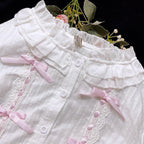 This short-cut cotton blouse features a flattering high-waist design and an elastic hem adorned with delicate ruffles. Crafted in versatile black and sweet pink, its breathable fabric and tailored fit offer comfort for daily wear. The cropped length perfectly pairs with high-waisted skirts or jumpers, blending playful charm with practical elegance for cute Lolita coordinates.