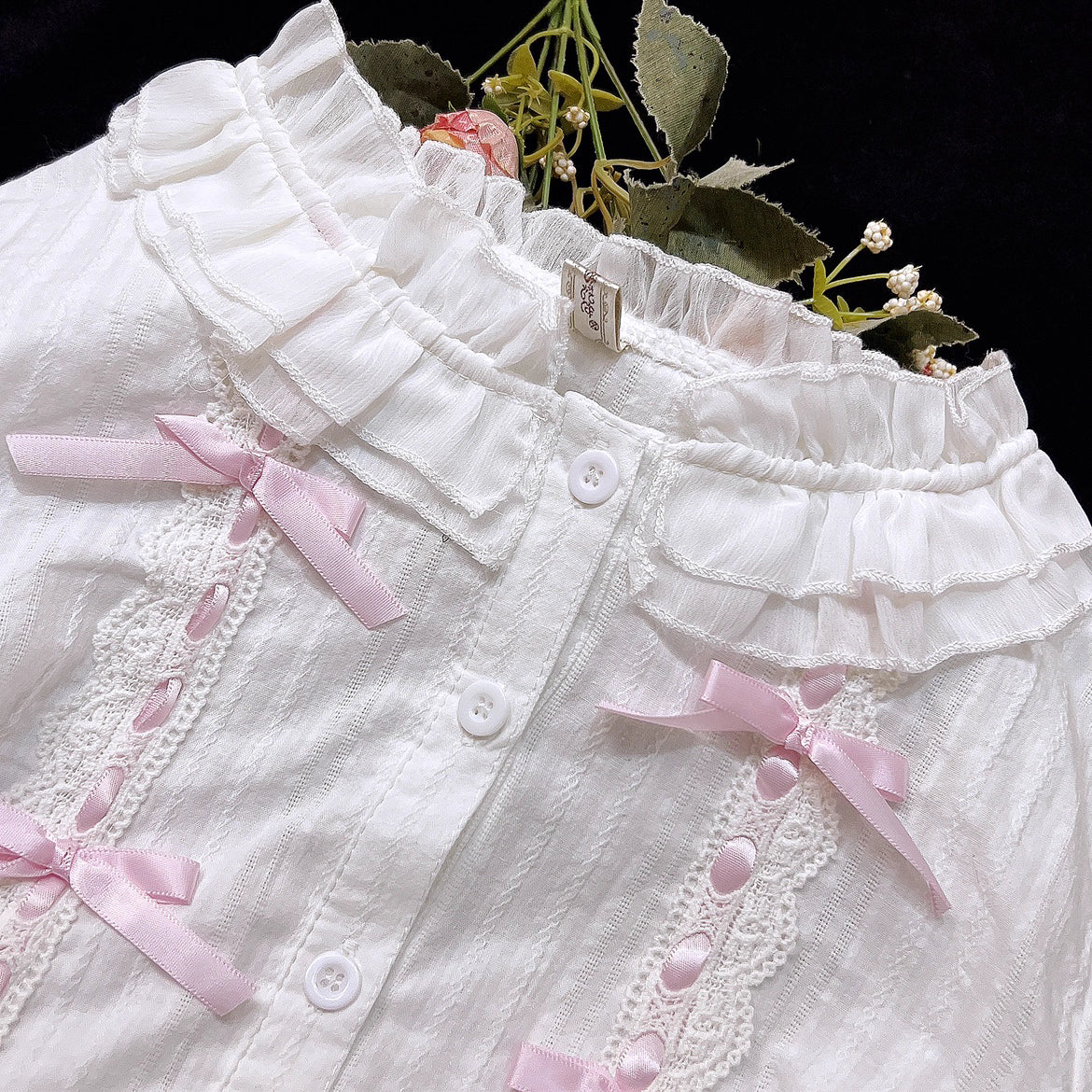 This short-cut cotton blouse features a flattering high-waist design and an elastic hem adorned with delicate ruffles. Crafted in versatile black and sweet pink, its breathable fabric and tailored fit offer comfort for daily wear. The cropped length perfectly pairs with high-waisted skirts or jumpers, blending playful charm with practical elegance for cute Lolita coordinates.