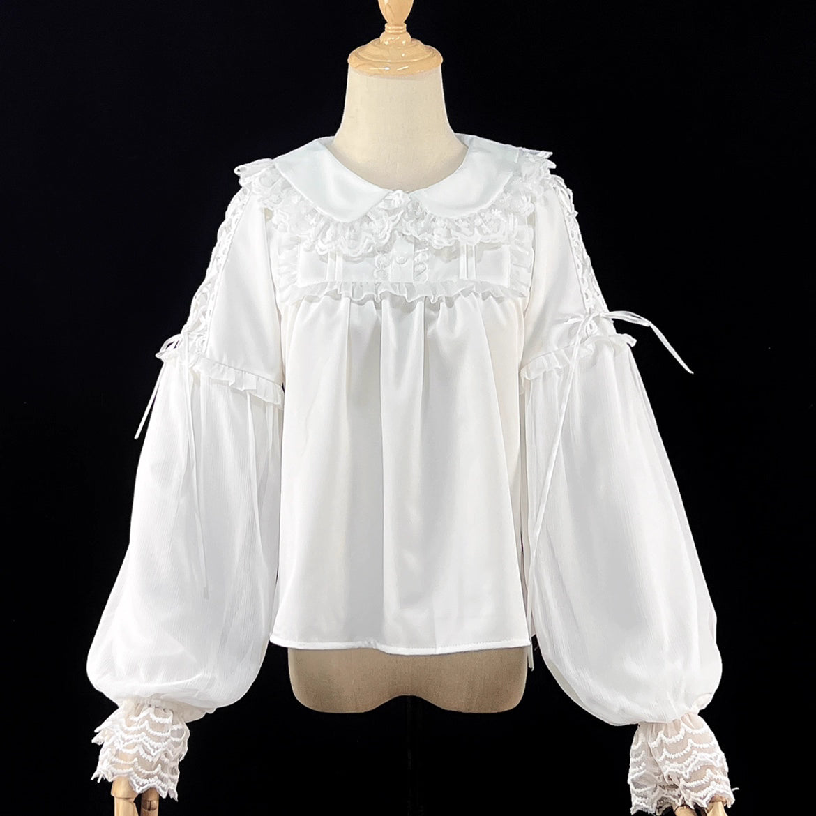 Embodying the freshness of spring, this delicate blouse features a lace-trimmed doll collar adorned with satin ribbons and soft bishop sleeves. The lightweight fabric and sweet design make it perfect for layering under jumpers or dresses. Its romantic details capture a whimsical, youthful charm, ideal for creating enchanting coordinations that blend vintage elegance with modern Lolita sweetness.