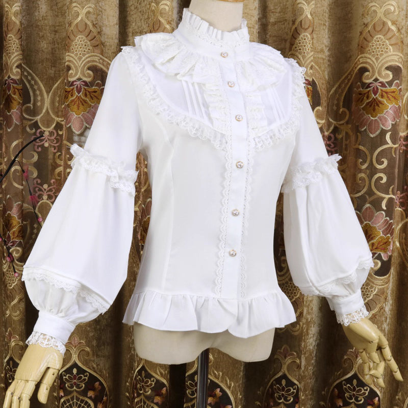This vintage-inspired blouse features an elegant stand collar and voluminous lantern sleeves crafted from lightweight chiffon. The tailored silhouette offers a flattering fit, while delicate lace details add romantic refinement. Perfect for layering under dresses or jumpers, it blends retro sophistication with Lolita elegance, creating a timeless foundation for both classic and sweet coordinates.