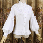 This vintage-inspired blouse features an elegant stand collar and voluminous lantern sleeves crafted from lightweight chiffon. The tailored silhouette offers a flattering fit, while delicate lace details add romantic refinement. Perfect for layering under dresses or jumpers, it blends retro sophistication with Lolita elegance, creating a timeless foundation for both classic and sweet coordinates.