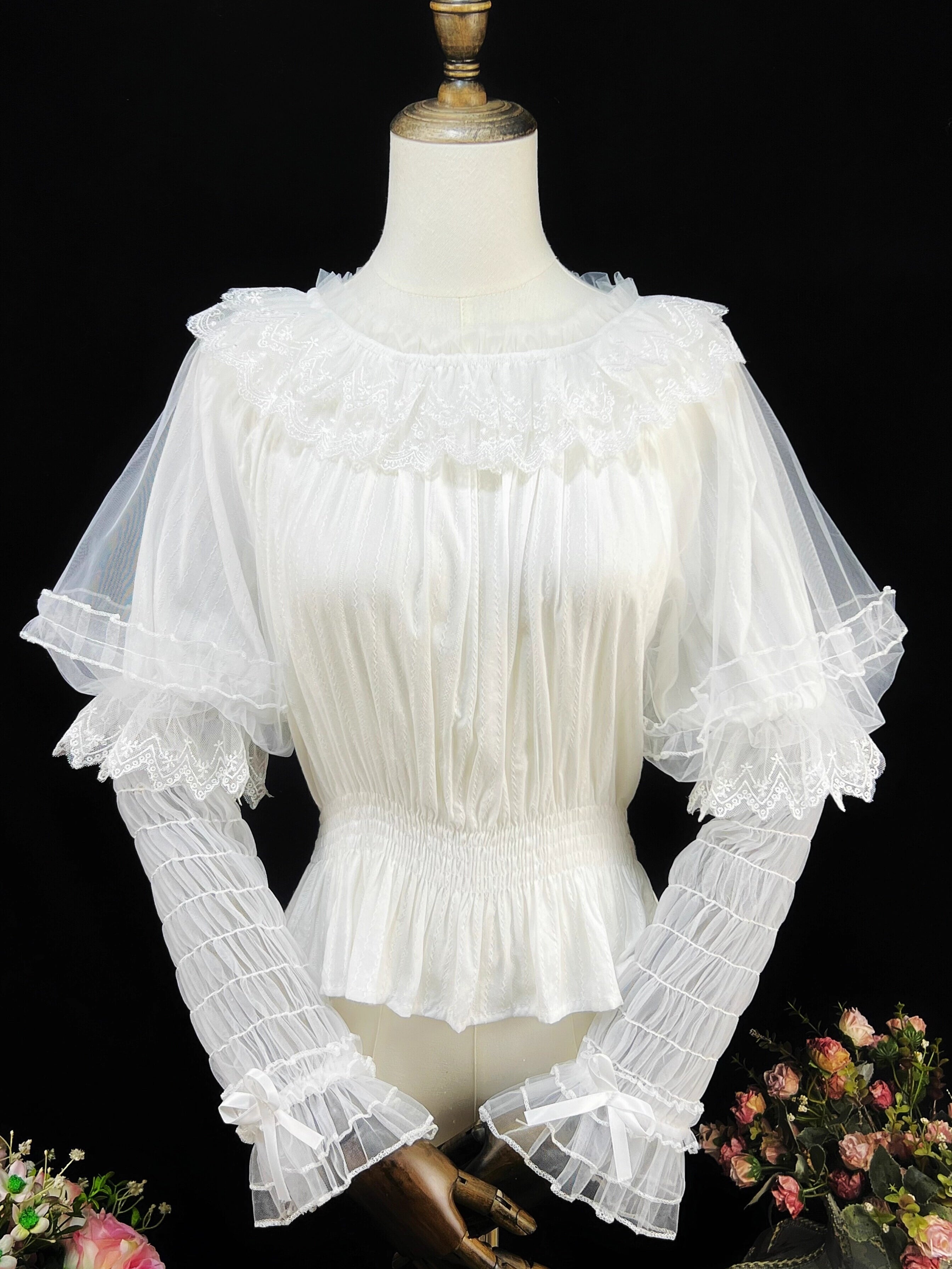 This retro-inspired blouse blends soft cotton with delicate mesh panels for textured elegance. The round neckline and relaxed fit offer timeless comfort, while subtle vintage details create a versatile layering piece. Perfect under jumpers or dresses, it effortlessly bridges classic and sweet Lolita styles with understated sophistication.