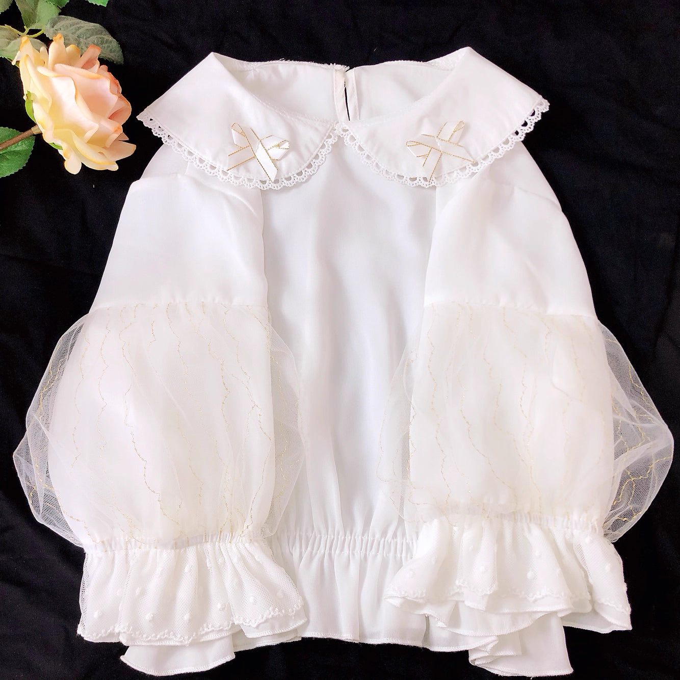 Design Concept:
This Lolita blouse features a delicate doll collar and a cropped, short silhouette, designed as a versatile inner layer for JSKs and other Lolita outfits. The soft chiffon fabric adds a gentle drape and elegant touch, making it suitable for layering or wearing on its own. Available in White and Black, it complements both sweet and Gothic Lolita styles.
