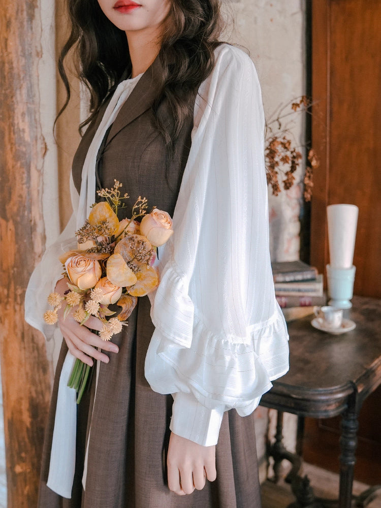 Inspired by the opulent elegance of the French court, this blouse is a masterpiece of romantic detail. Crafted in a subtly shimmering fabric, it features dramatic puff sleeves and delicate ruffled accents. The adjustable tie-front closure allows for a customizable fit, blending historical grandeur with modern wearability. This piece is designed for those who wish to infuse their everyday style with a touch of aristocratic fantasy and timeless grace.
