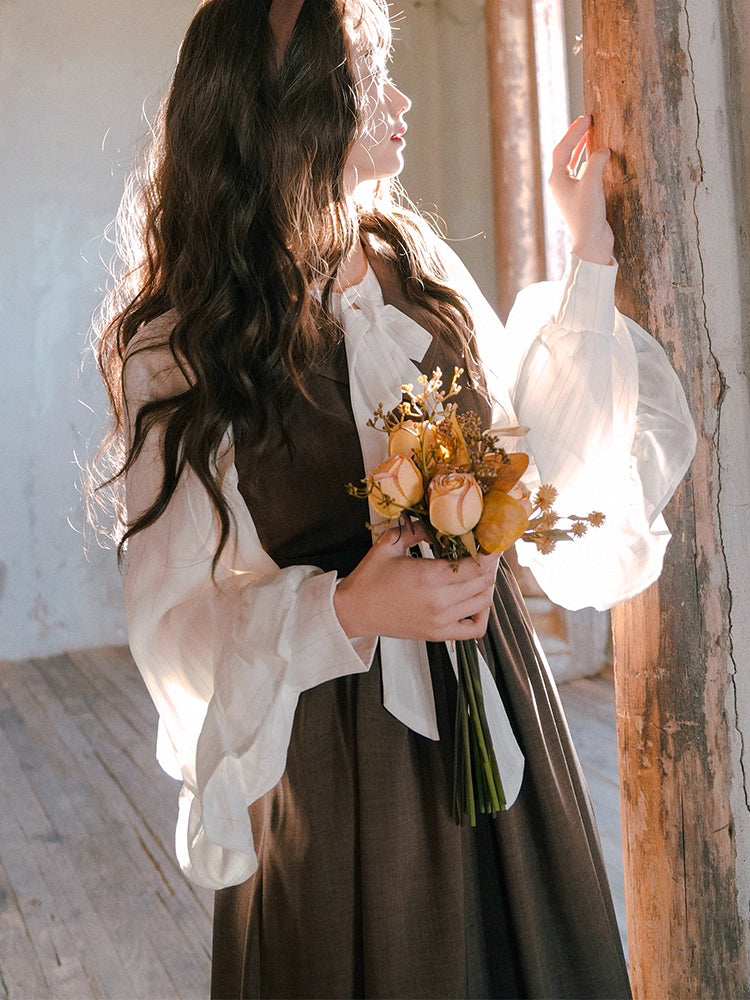 Inspired by the opulent elegance of the French court, this blouse is a masterpiece of romantic detail. Crafted in a subtly shimmering fabric, it features dramatic puff sleeves and delicate ruffled accents. The adjustable tie-front closure allows for a customizable fit, blending historical grandeur with modern wearability. This piece is designed for those who wish to infuse their everyday style with a touch of aristocratic fantasy and timeless grace.