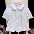 Inspired by moonlit summer nights, this delicate blouse features a classic Peter Pan collar and soft short sleeves. Crafted in pure white, its lightweight fabric and sweet design offer effortless versatility for daily wear. The subtle elegance captures a dreamy, youthful charm, perfect for pairing with summer skirts or jumpers. This piece embodies romantic simplicity, blending timeless Lolita aesthetics with modern comfort for enchanting warm-weather coordinations.