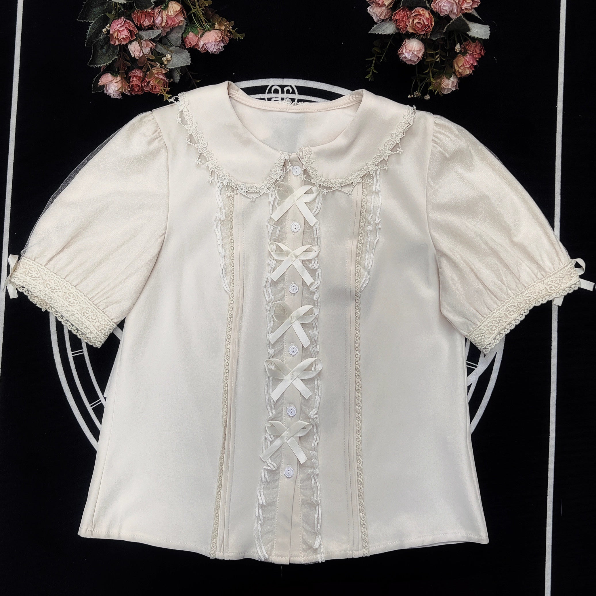 Inspired by moonlit summer nights, this delicate blouse features a classic Peter Pan collar and soft short sleeves. Crafted in pure white, its lightweight fabric and sweet design offer effortless versatility for daily wear. The subtle elegance captures a dreamy, youthful charm, perfect for pairing with summer skirts or jumpers. This piece embodies romantic simplicity, blending timeless Lolita aesthetics with modern comfort for enchanting warm-weather coordinations.