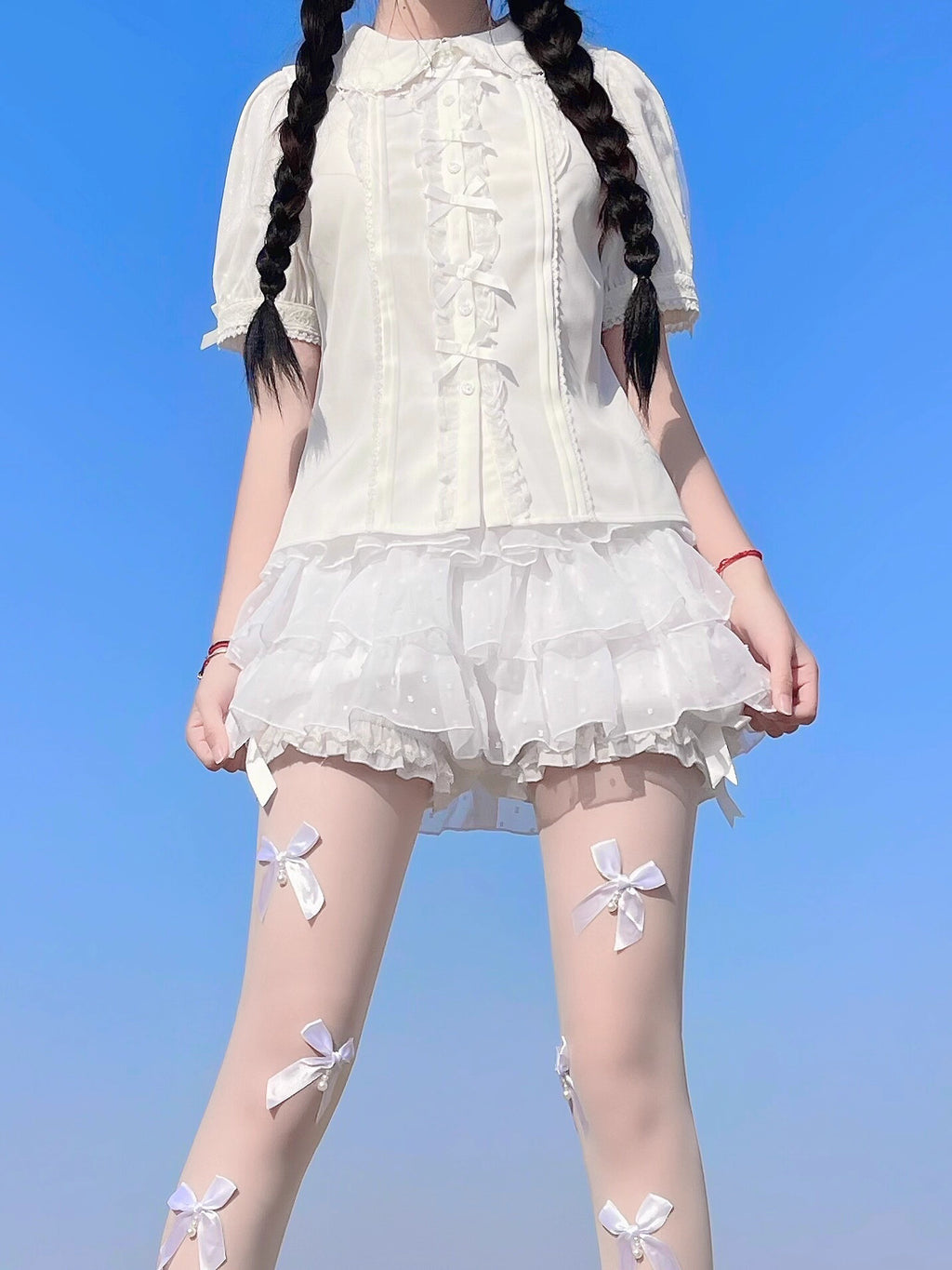 Inspired by moonlit summer nights, this delicate blouse features a classic Peter Pan collar and soft short sleeves. Crafted in pure white, its lightweight fabric and sweet design offer effortless versatility for daily wear. The subtle elegance captures a dreamy, youthful charm, perfect for pairing with summer skirts or jumpers. This piece embodies romantic simplicity, blending timeless Lolita aesthetics with modern comfort for enchanting warm-weather coordinations.