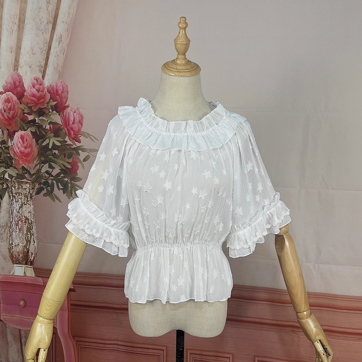 Delve into dreamy elegance with this Lolita chiffon blouse. Delicate prints adorn the lightweight, sheer fabric, while the elastic neckline offers a comfortable yet chic fit. Designed as a crop top, it pairs perfectly with JSK dresses, adding a layer of ethereal charm. The short sleeves and breathable material make it ideal for summer wear. Embrace a blend of whimsy and sophistication, perfect for creating a captivating Lolita ensemble that’s both graceful and stylish.