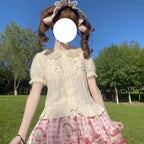 Design Concept:
This sweet Lolita blouse is designed with a short-sleeve cut and adorned with a delicate bow, perfectly capturing a cute and youthful charm. Crafted in white, soft light yellow, and pastel pink, the blouse offers versatile styling options to suit different moods and coordinates. The lightweight fabric ensures comfort while maintaining a refined silhouette, making it an ideal piece to layer under JSKs or pair with Lolita skirts. Whether for daily wear or a tea party, this blouse adds a playfu