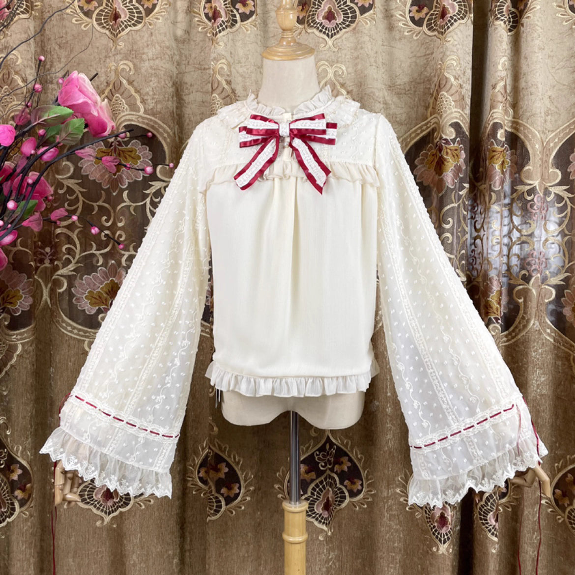 This elegant blouse masterfully blends Victorian romance with subtle Chinese-inspired aesthetics. The dramatic double-layer bishop sleeves and delicate drawstring details create a luxurious, poetic silhouette. Topped with a classic bow tie, it offers a timeless look. Designed for the modern Lolita enthusiast, this undershirt is crafted from premium materials for both comfort and sophistication, making it the perfect foundational piece for creating a statement layered outfit that is both graceful and uniquel